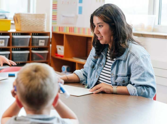 teacher talking to students at table