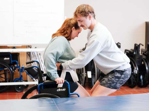 man helping a woman out of a wheelchair
